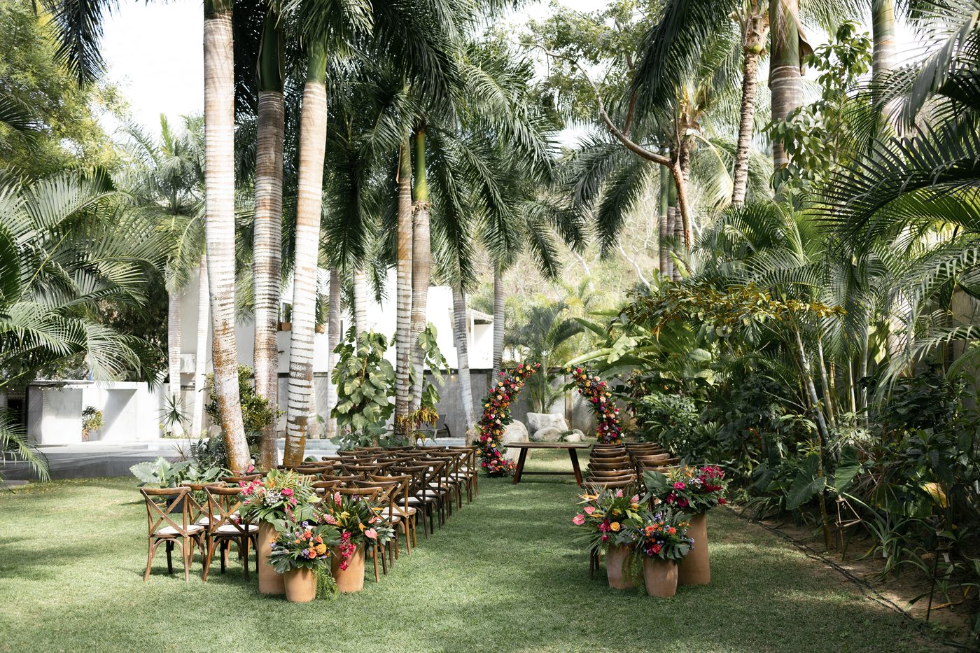 Ceremony setup with floral arrangements and palm trees