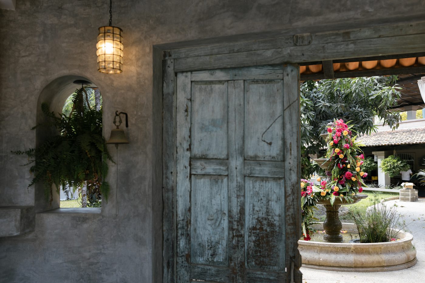 Hacienda entrance with blue door and floral fountain